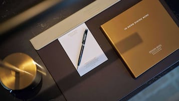 A menu, a pen, and a booklet on a table.