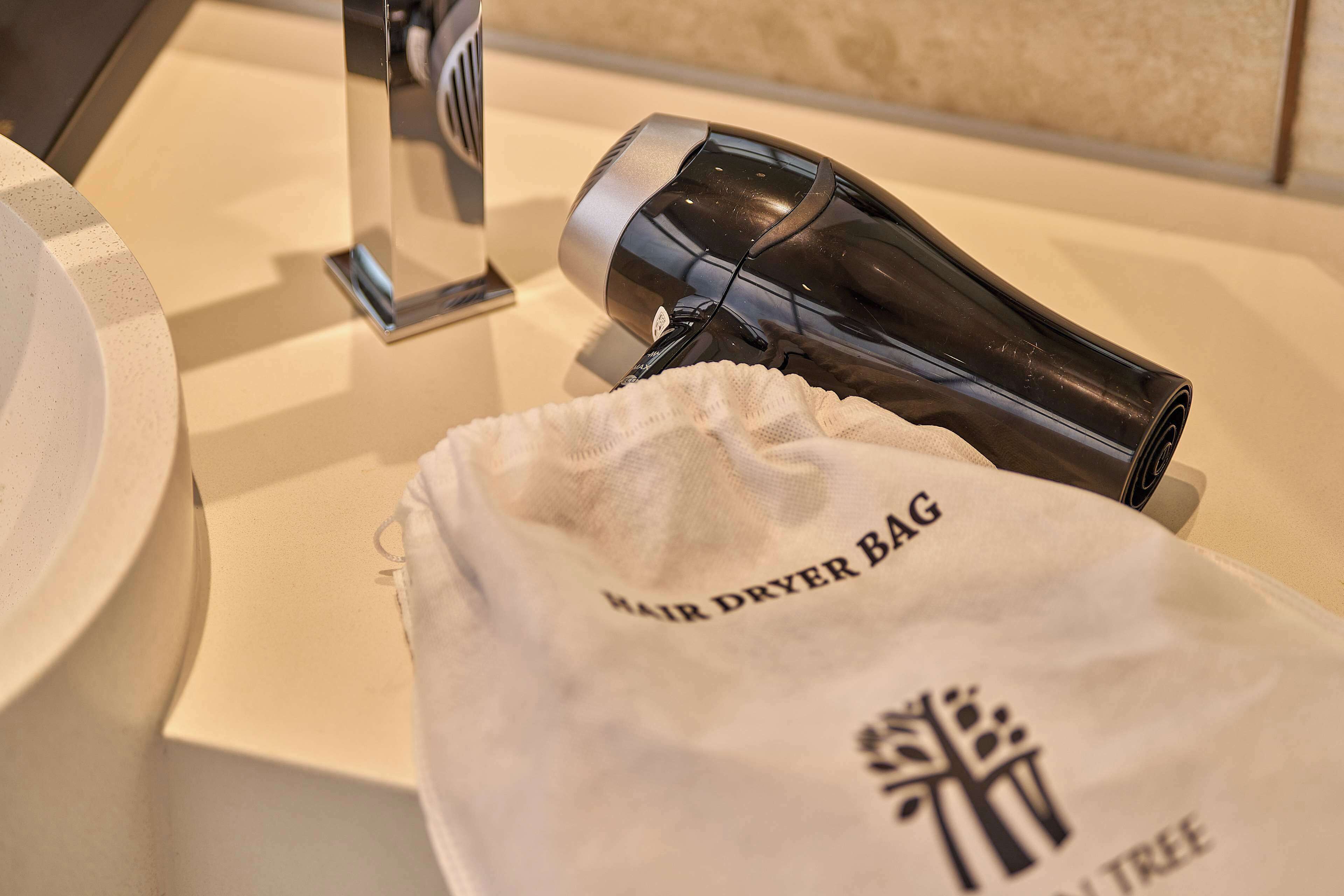 Una bolsa para secador de pelo y un secador de pelo sobre una encimera de baño.