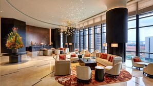 A spacious lobby with a modern design, featuring a reception desk, comfortable seating areas, and large windows offering city views. - Pavilion Hotel Kuala Lumpur Managed by Banyan Tree (Kuala Lumpur)