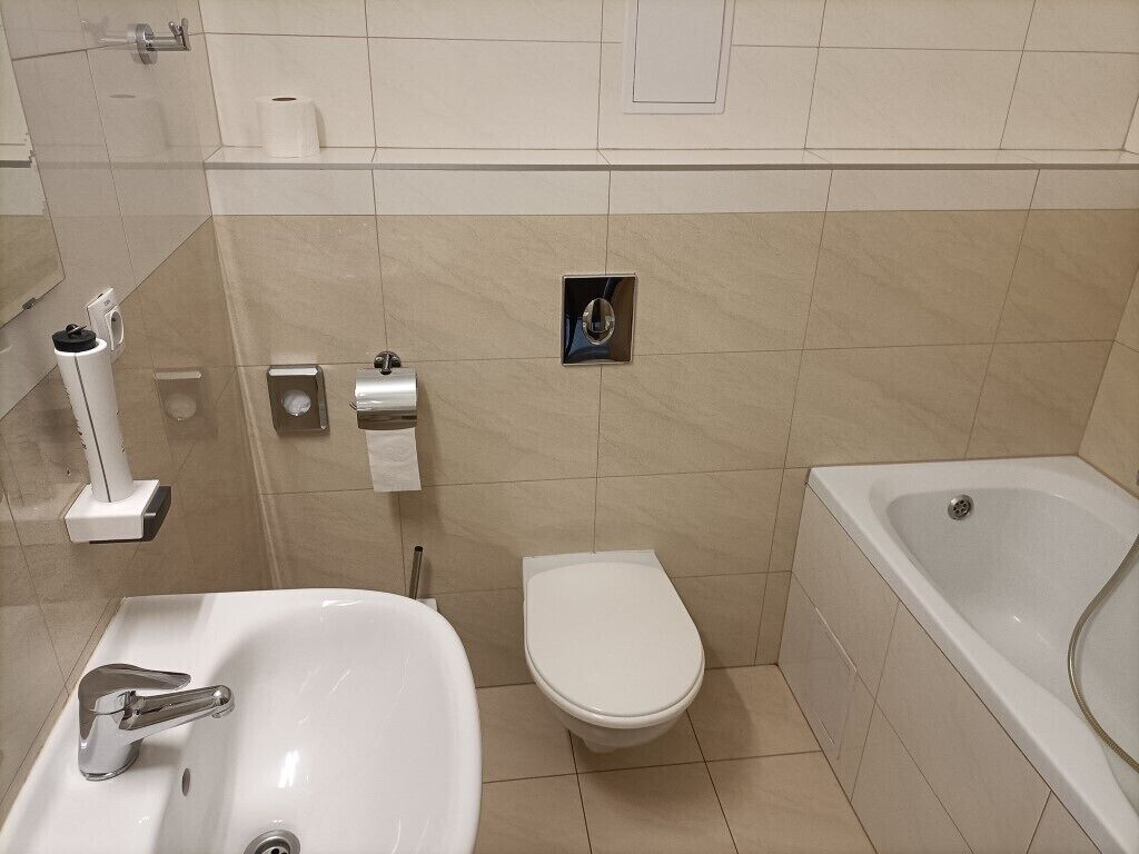 A bathroom with a sink, toilet, and bathtub.