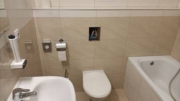 A bathroom with a sink, toilet, and bathtub.