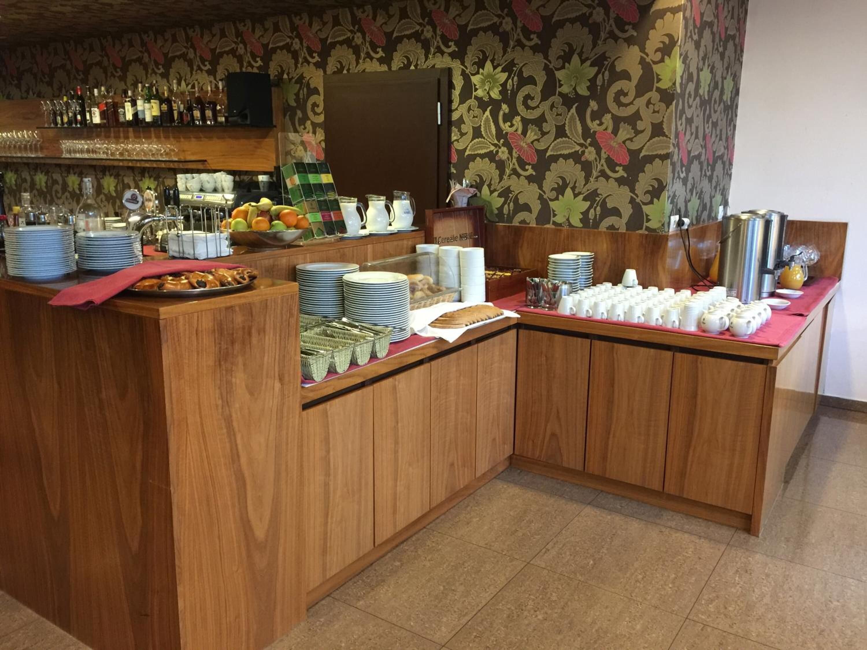 A breakfast bar with a variety of food items, including fruits, pastries, and beverages.