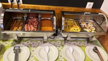 Een buffetopstelling met diverse gerechten en bestek.