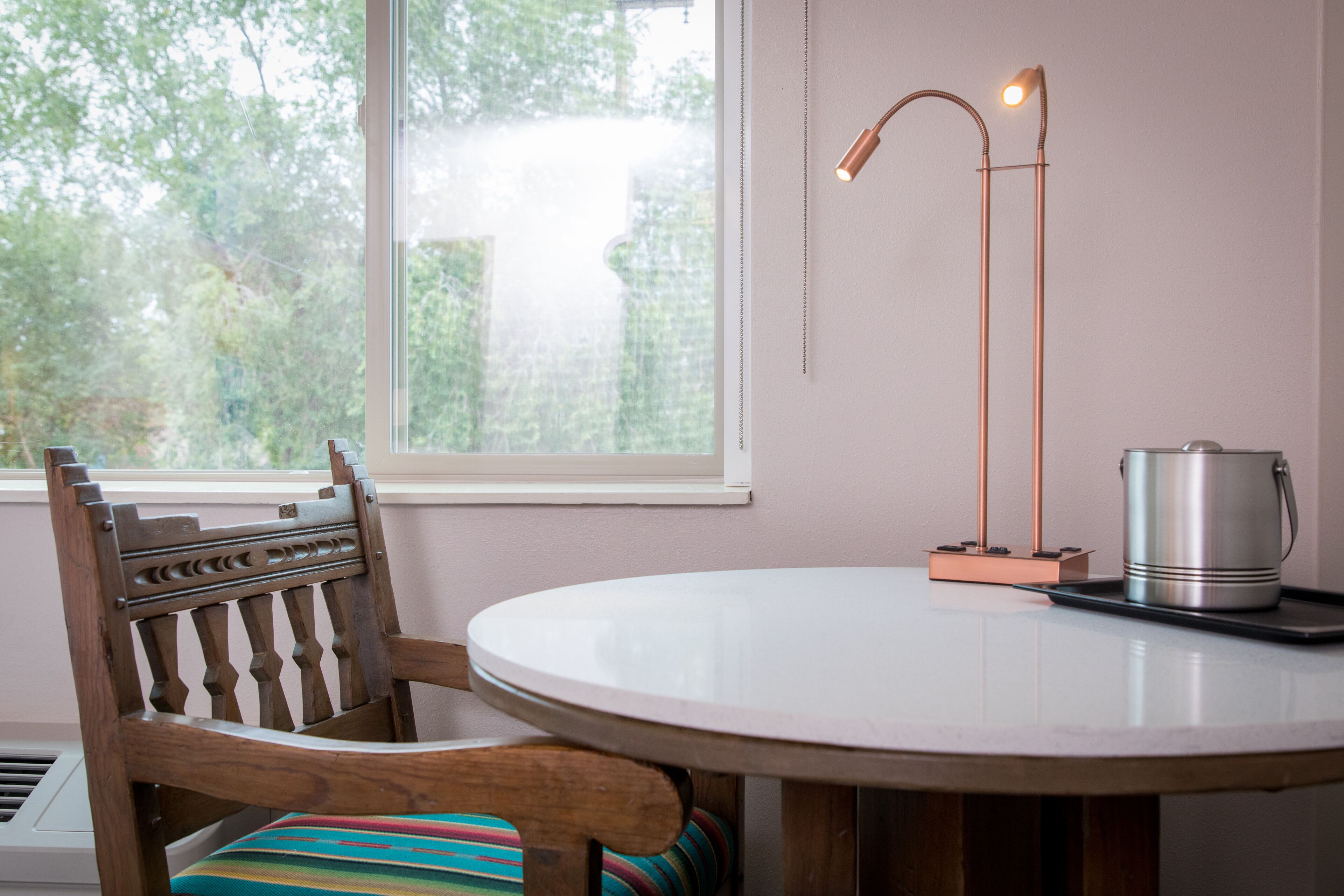 A round table with a metal pot and a lamp.