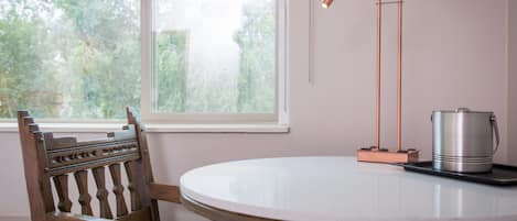 A round table with a metal pot and a lamp.