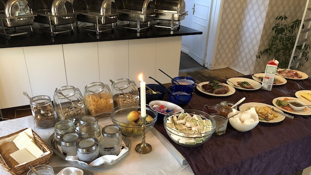 Een buffet met verschillende soorten eten, bestek en glazen recipiënten.