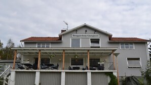 Een gebouw met twee verdiepingen, met een bord waarop staat 'Berggårdens Gästgiveri'.