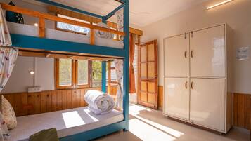 Habitación con literas, un armario y una ventana.