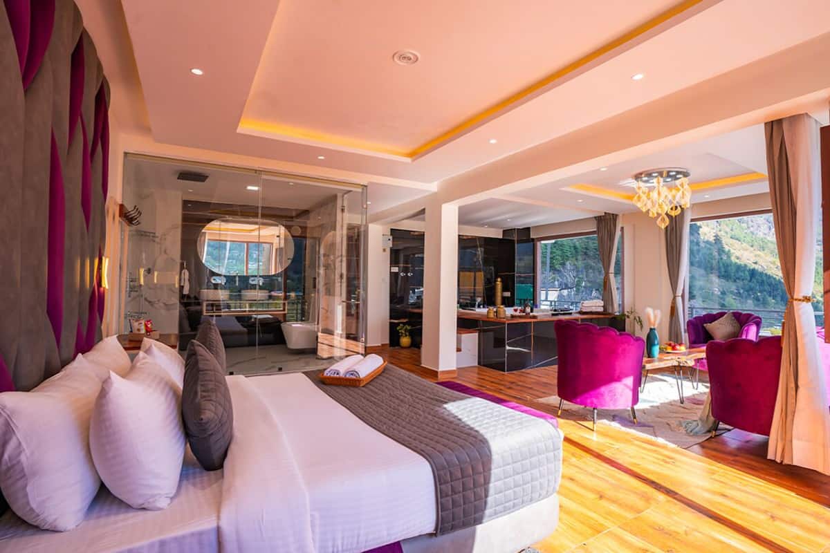 Una habitación de hotel moderna con una cama grande, un escritorio y vistas al exterior.