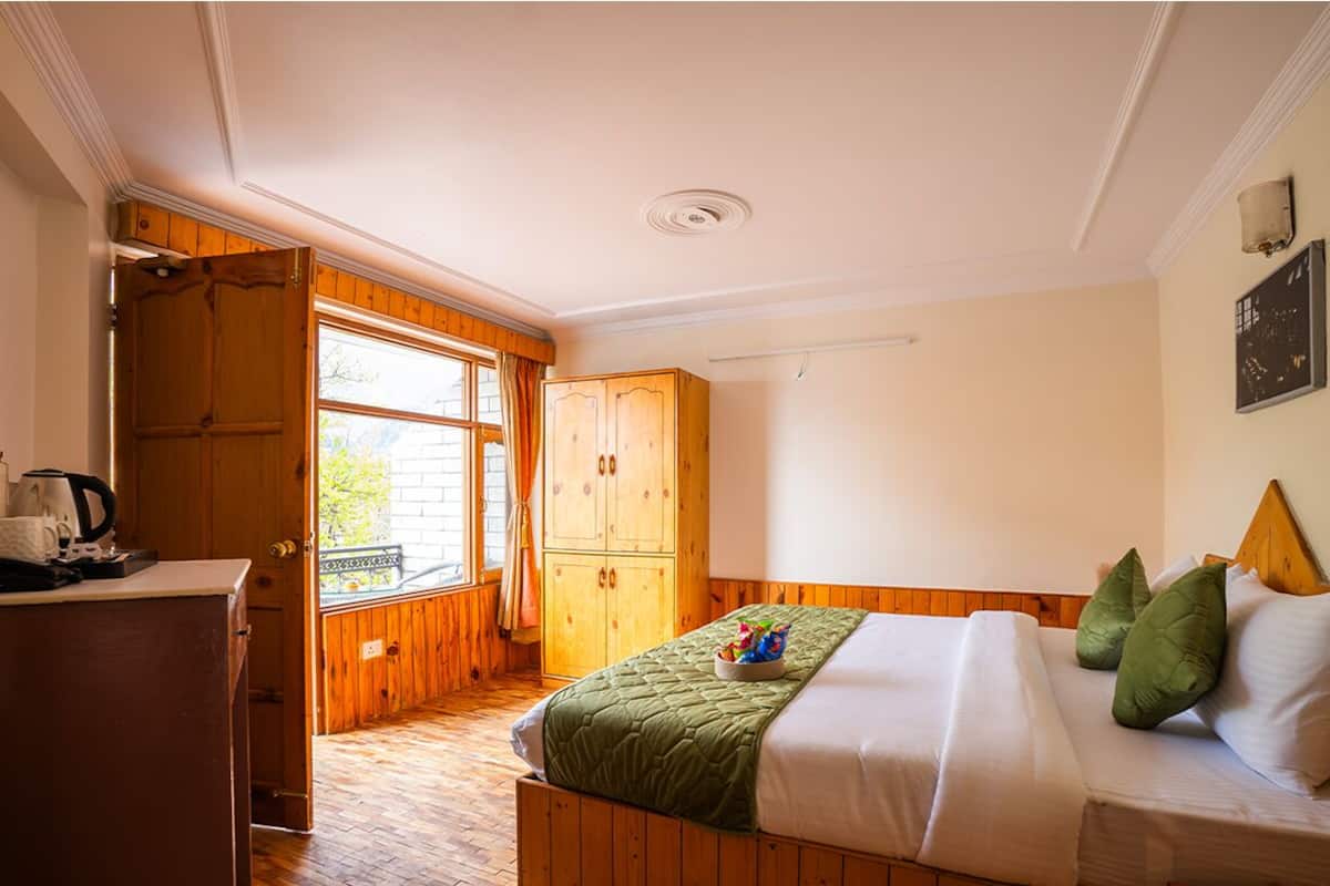 Un dormitorio con cama, armario de madera y ventana con cortinas.