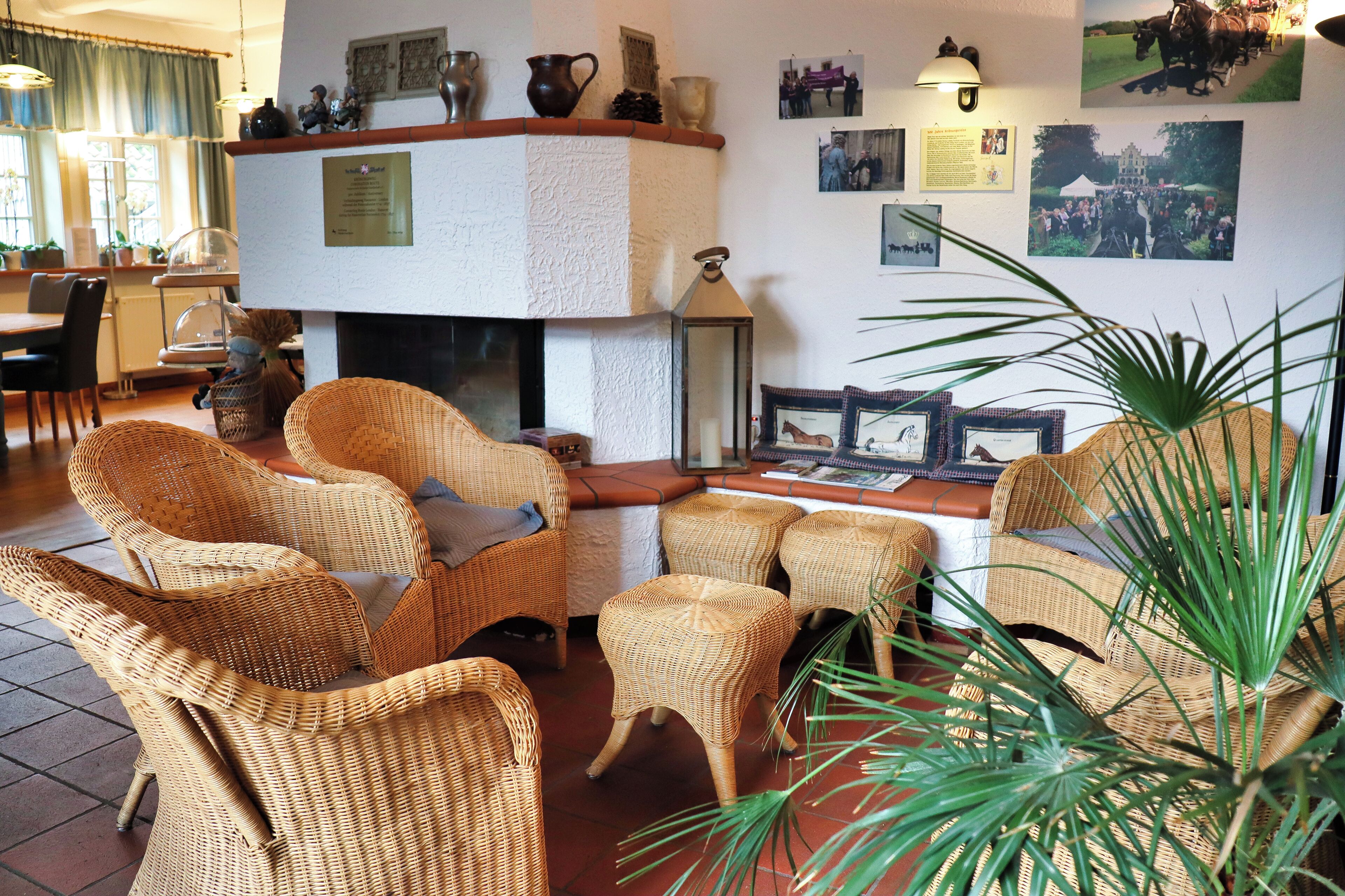 A room with wicker furniture, a fireplace, and wall-mounted pictures.