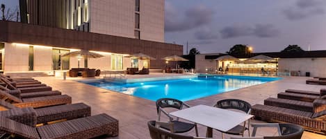 Alberca al aire libre y camastros