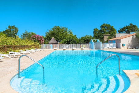 Una piscina al aire libre de temporada, sombrillas. Village Vacances Azureva Sigean