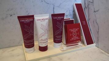 Une sélection de produits de la gamme Cinq Mondes, vendue dans le spa Cinq Mondes de Paris, comprenant une crème hydratante, un gel nettoyant et un shampooing, ainsi qu’une trousse de toilette.