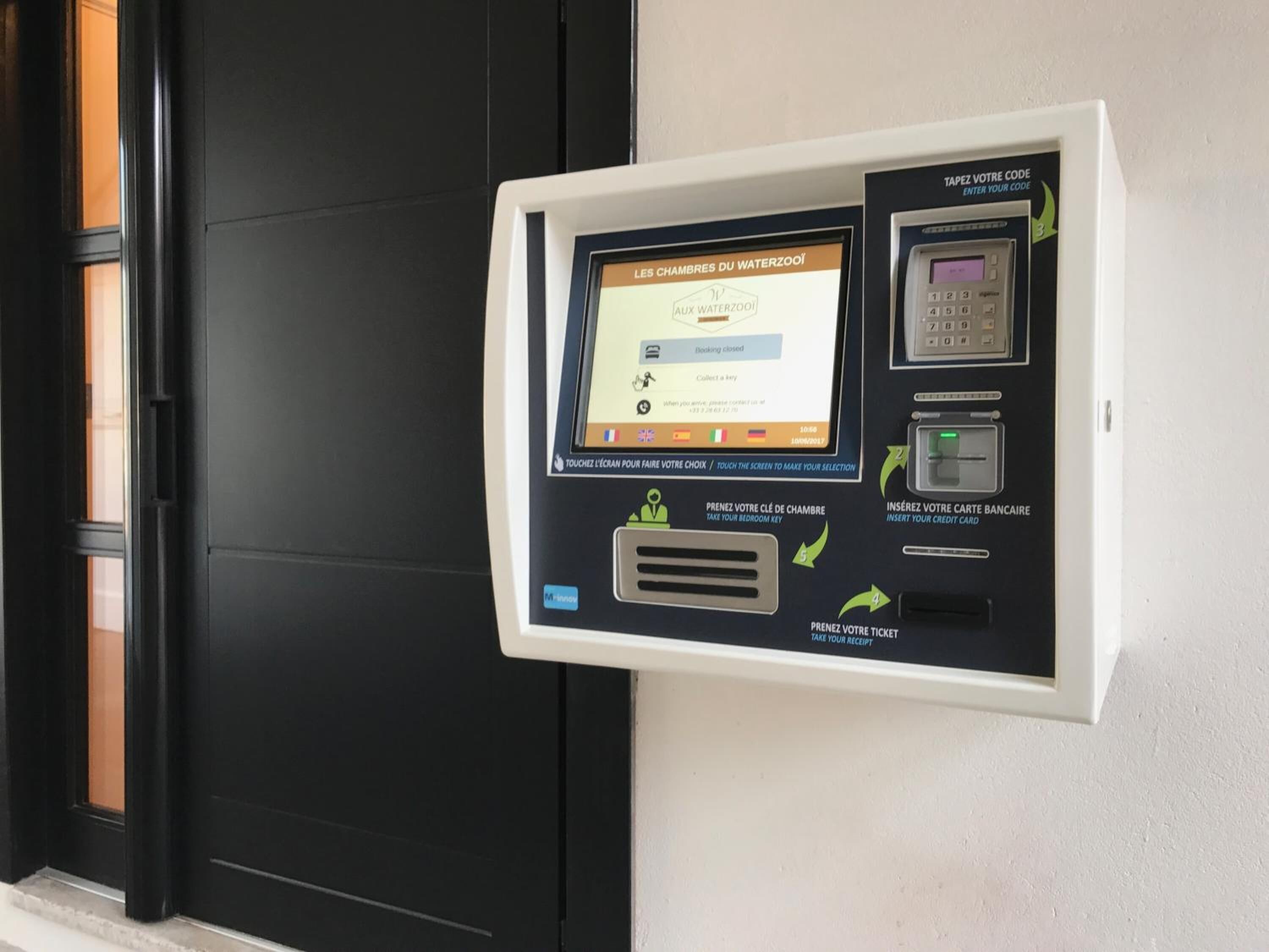 Quiosco de autoservicio con instrucciones para reservar habitaciones en Les Chambres du WaterZooï.
