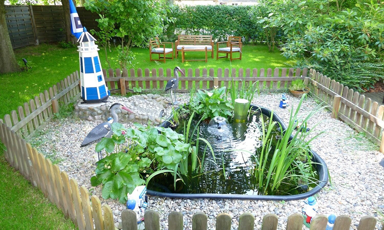 Ein Garten mit Teich, Holzpflanz und einer Bank.