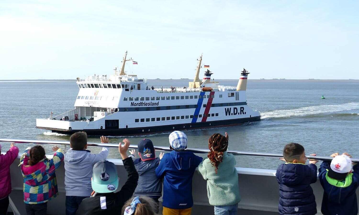 Un ferry llamado Nordfriesland con la identificación W.D.R. navegando en el agua.