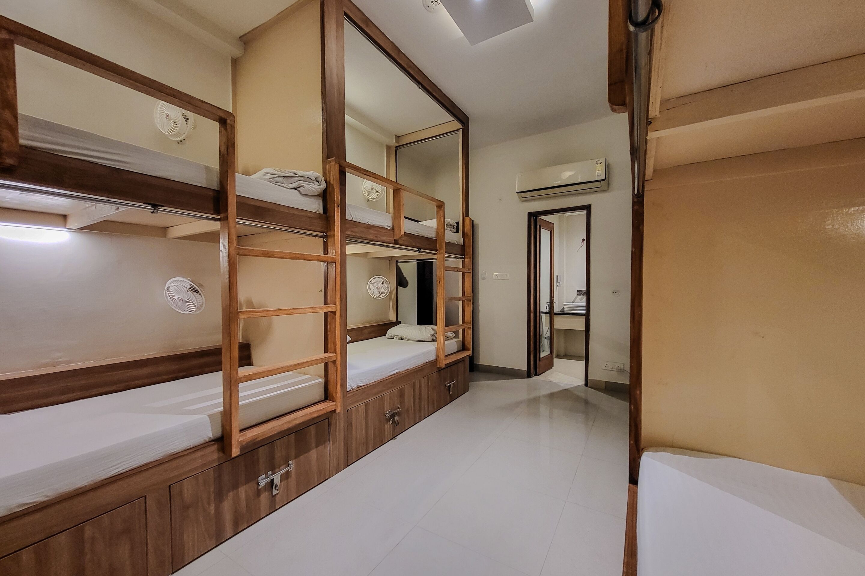Una habitación con literas, un espejo y un aire acondicionado.