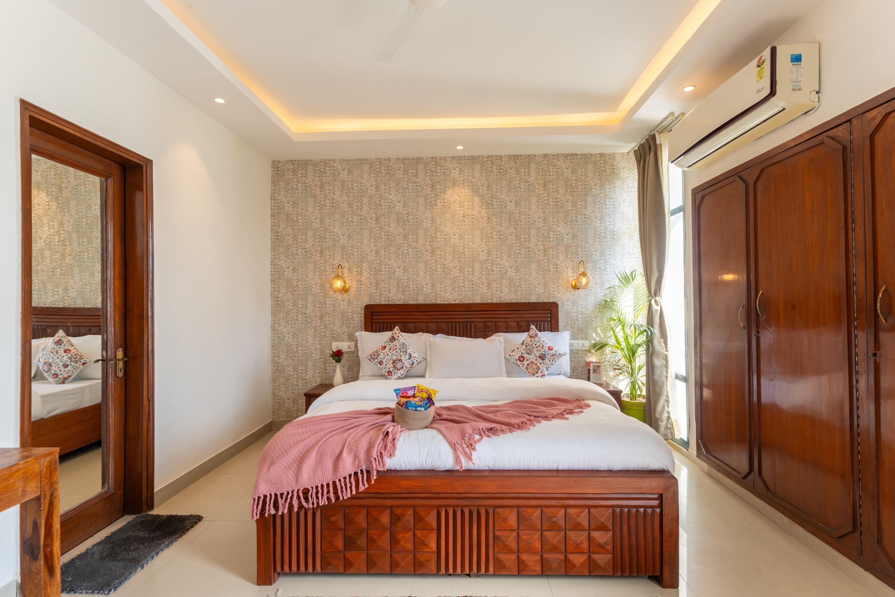 Un dormitorio con cama de madera, un armario grande y aire acondicionado instalado en la pared.