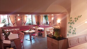 A restaurant with wooden furniture, a counter, and a wall with a plant. - Landgasthof Reichsadler (Hoechstaedt im Fichtelgebirge)