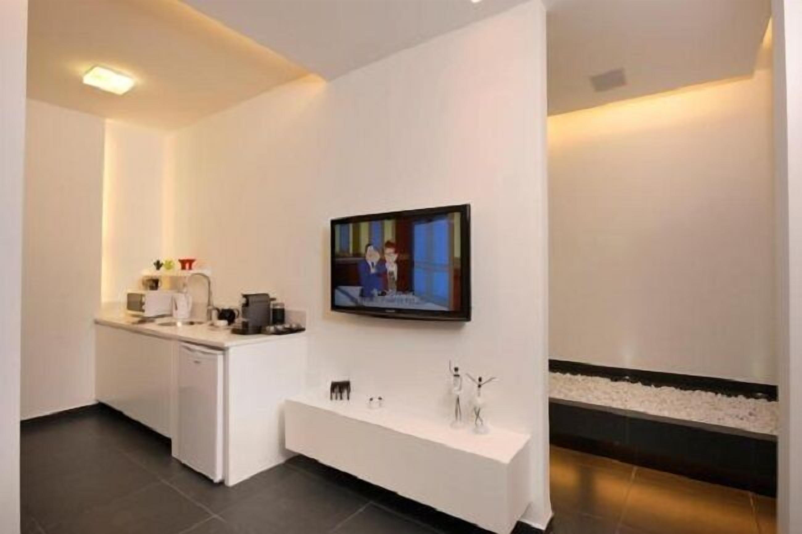 A modern bathroom with a white vanity, a small sink, and a mirror.