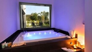 A hot tub with a view of a garden and a window above it. - Tal Kinneret (Emek HaYarden)