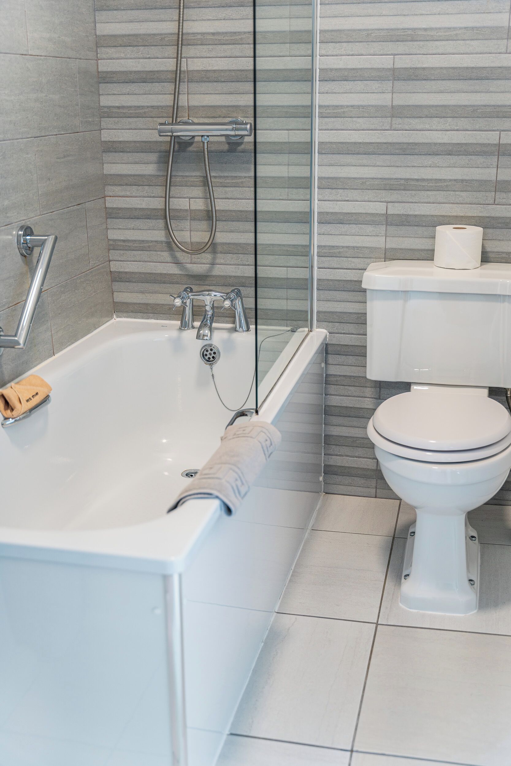 Ein modernes Badezimmer mit Badewanne, Dusche und Toilette.