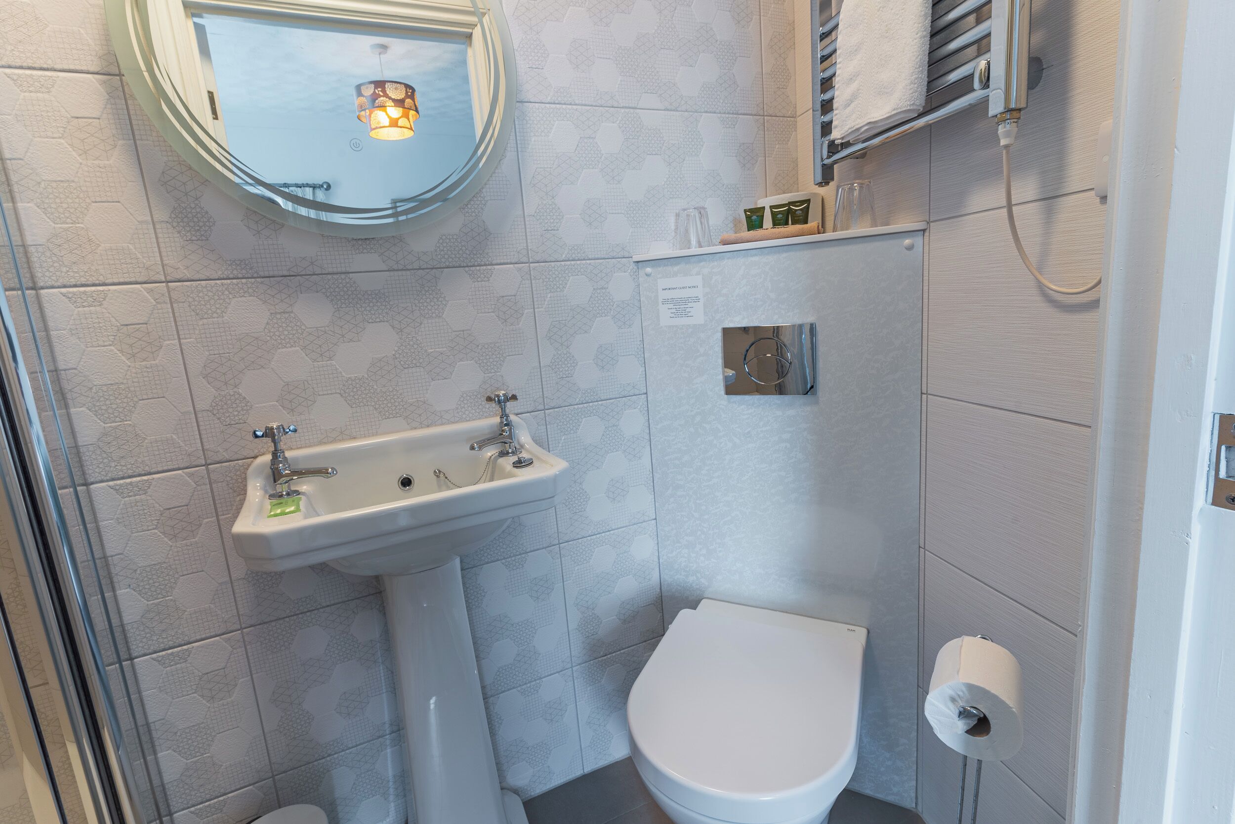 Ein kleines Badezimmer mit Waschbecken, Toilette und Spiegel.