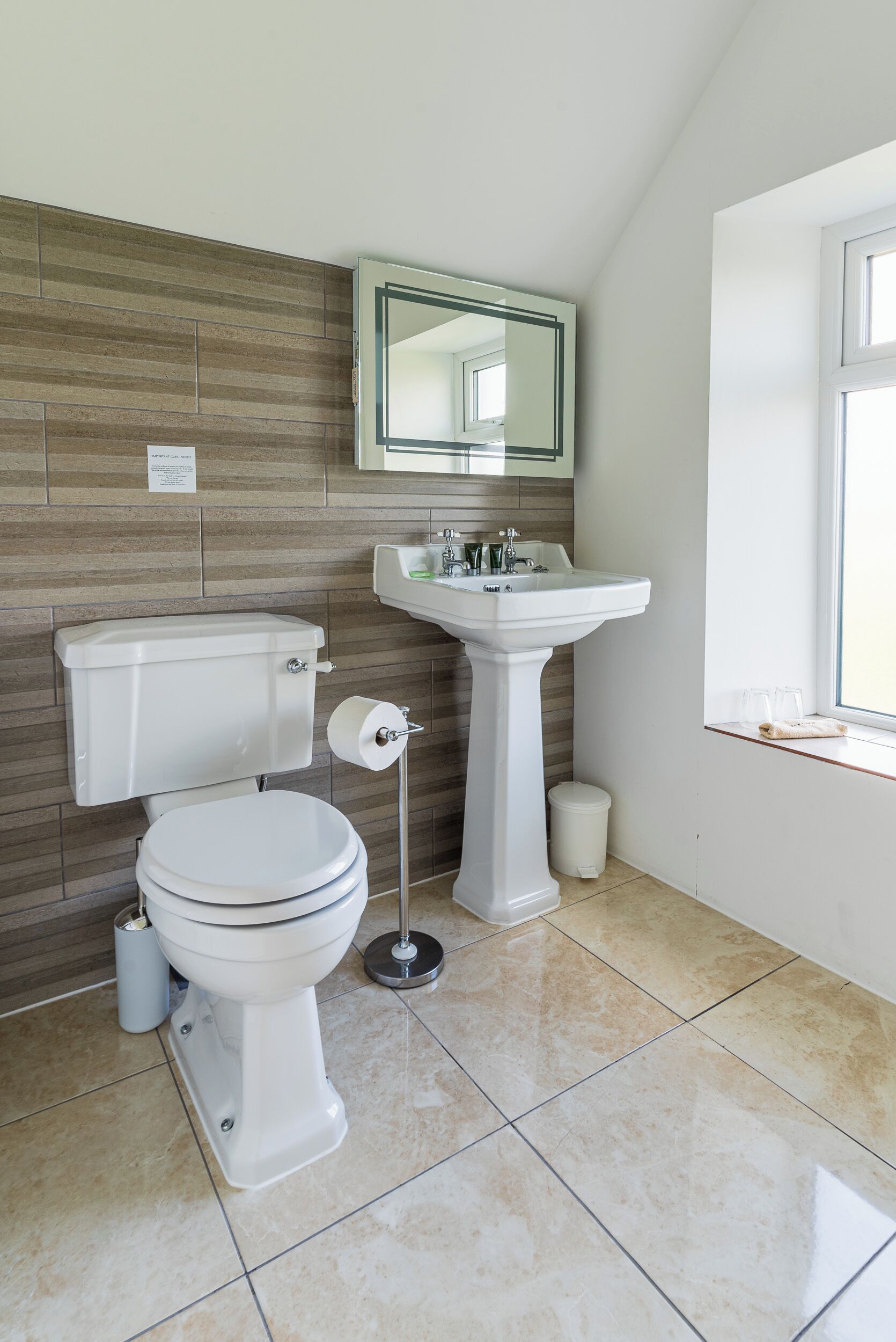 Une salle de bain avec des toilettes, un lavabo et un miroir.