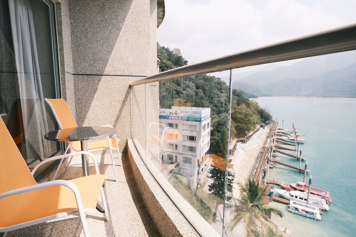 A balcony with a view of a marina and a building with a sign.