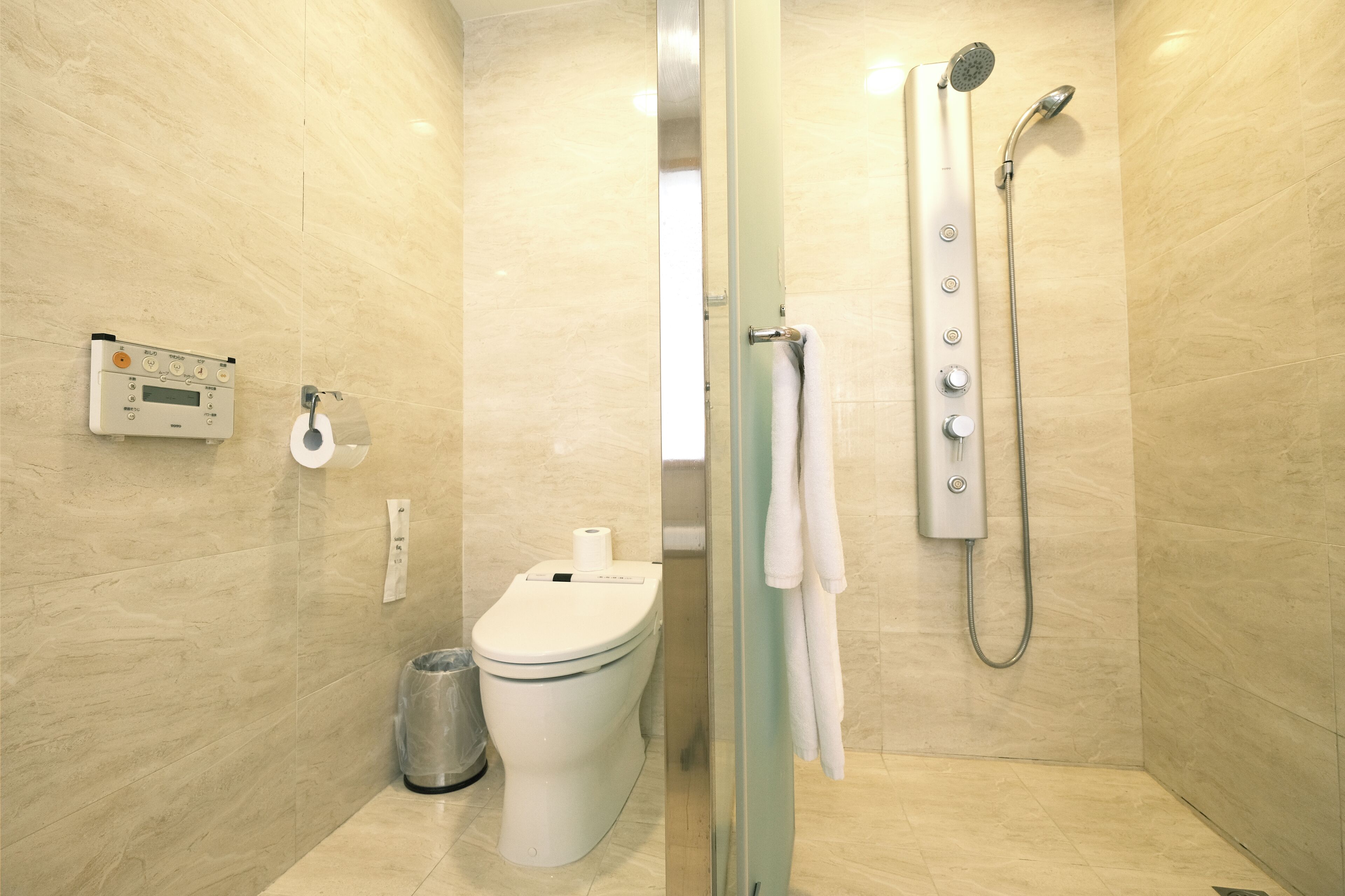 A modern bathroom with a toilet, bidet, and shower.