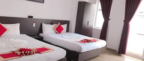 Una habitación de hotel con dos camas, un ventanal grande y un cuadro en la pared.