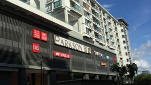 Ein mehrgeschossiges Gebäude mit einem auffälligen 'PARKSON'-Schild an der Fassade, das auf Geschäfts- oder Verkaufsräume hindeutet.