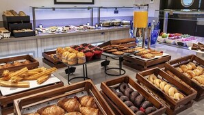 Un buffet proposant une variété de pâtisseries et de produits de boulangerie, présentés dans des caisses en bois.