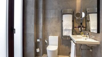 Une salle de bain moderne équipée de toilettes, d’un lavabo et de miroirs.