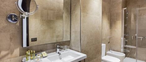 Un baño moderno con un espejo grande, un lavabo y una zona de ducha.