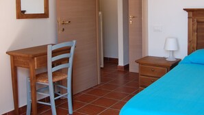 A bedroom with a bed, a desk with a chair, a nightstand, and a wardrobe. - Podere Valmarina (Grosseto)