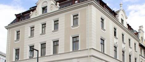 A multi-story building with a classical architectural style, featuring symmetrical windows and decorative elements on the facade.