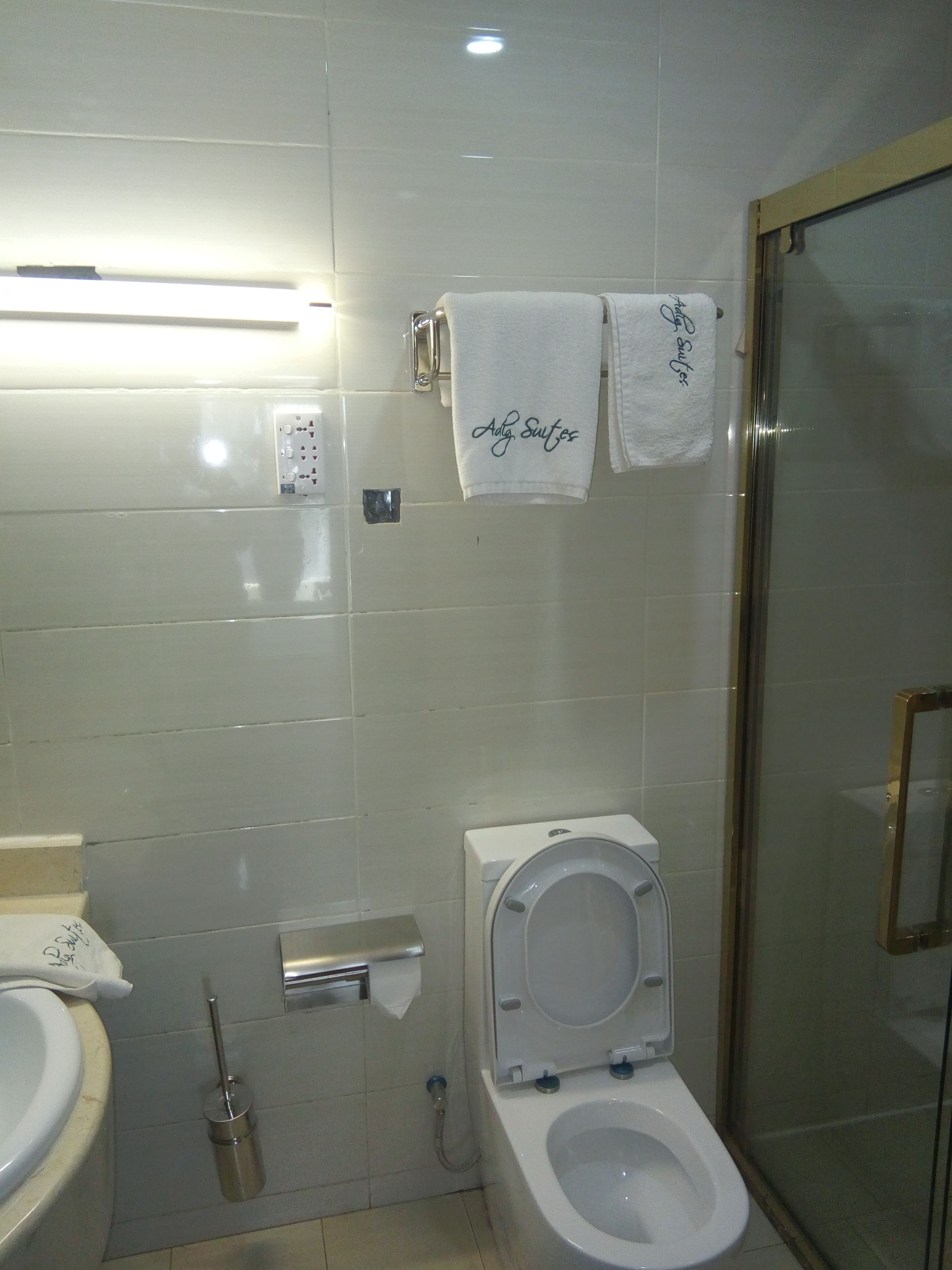 Un baño con inodoro, bidé y cabina de ducha de vidrio.