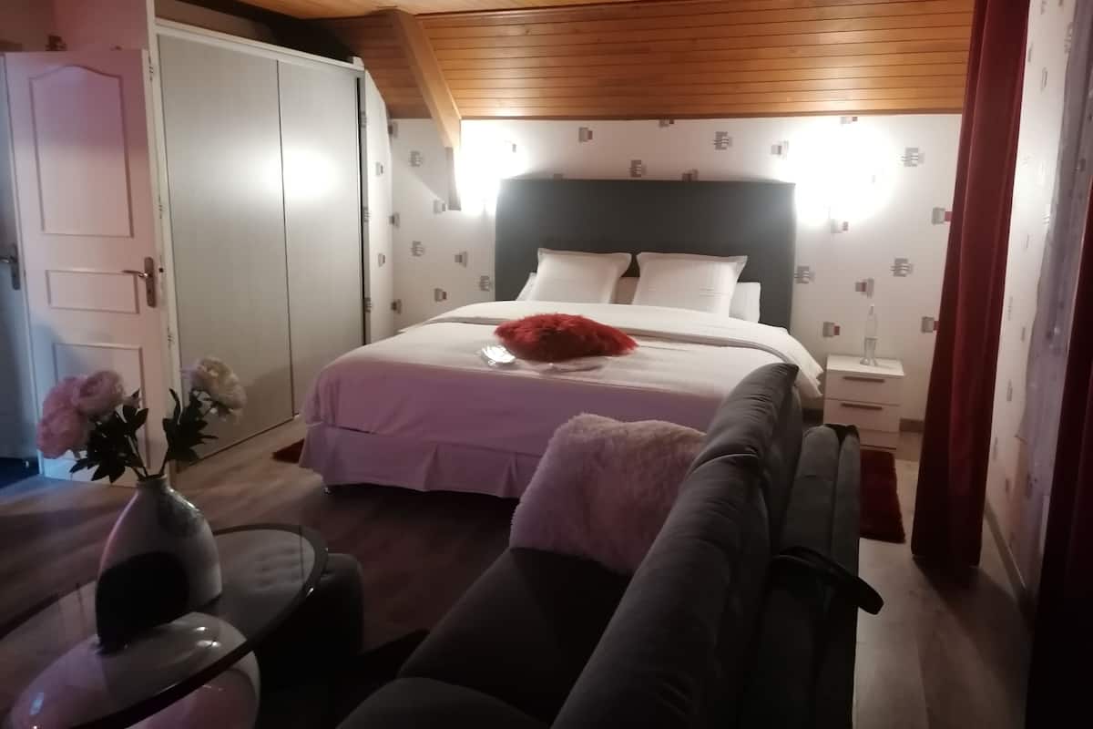 A bedroom with a bed, bedside table, and a nightstand.