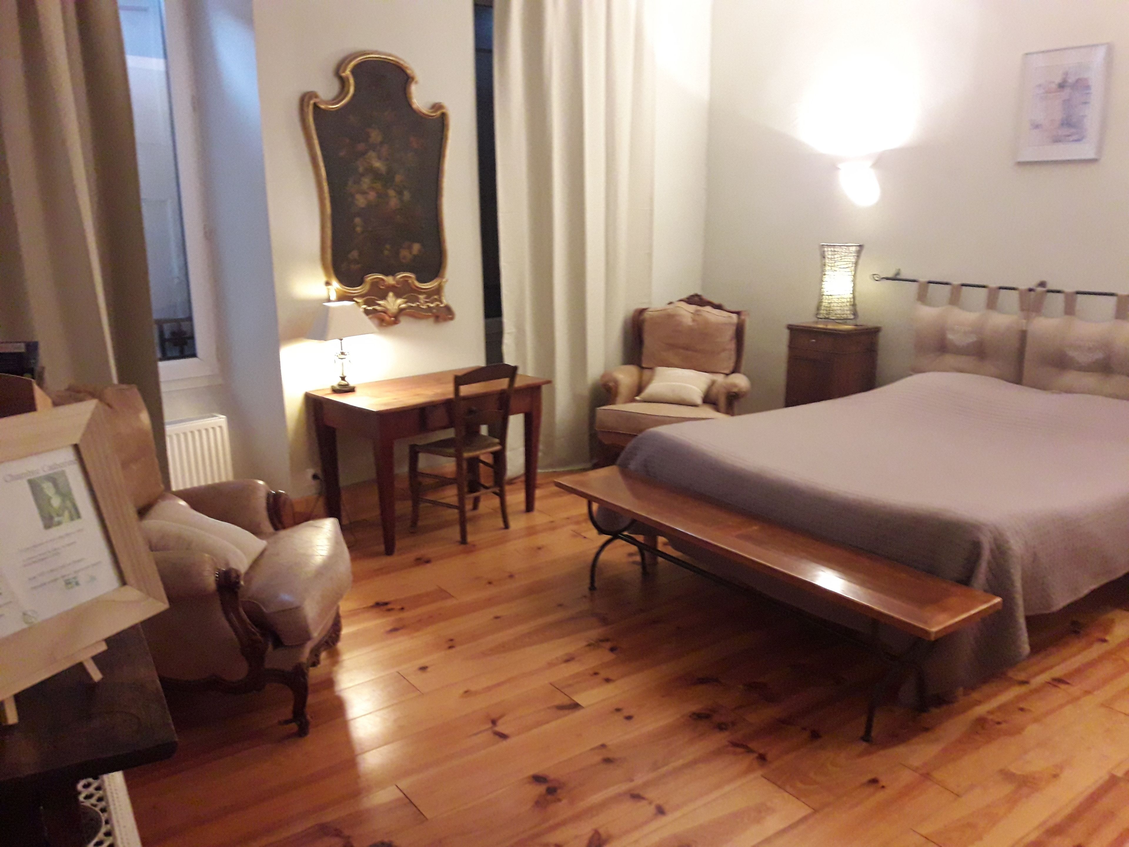 Un dormitorio con una cama, un escritorio, una silla y un banco.