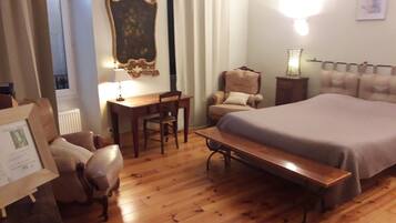 Un dormitorio con una cama, un escritorio, una silla y un banco.
