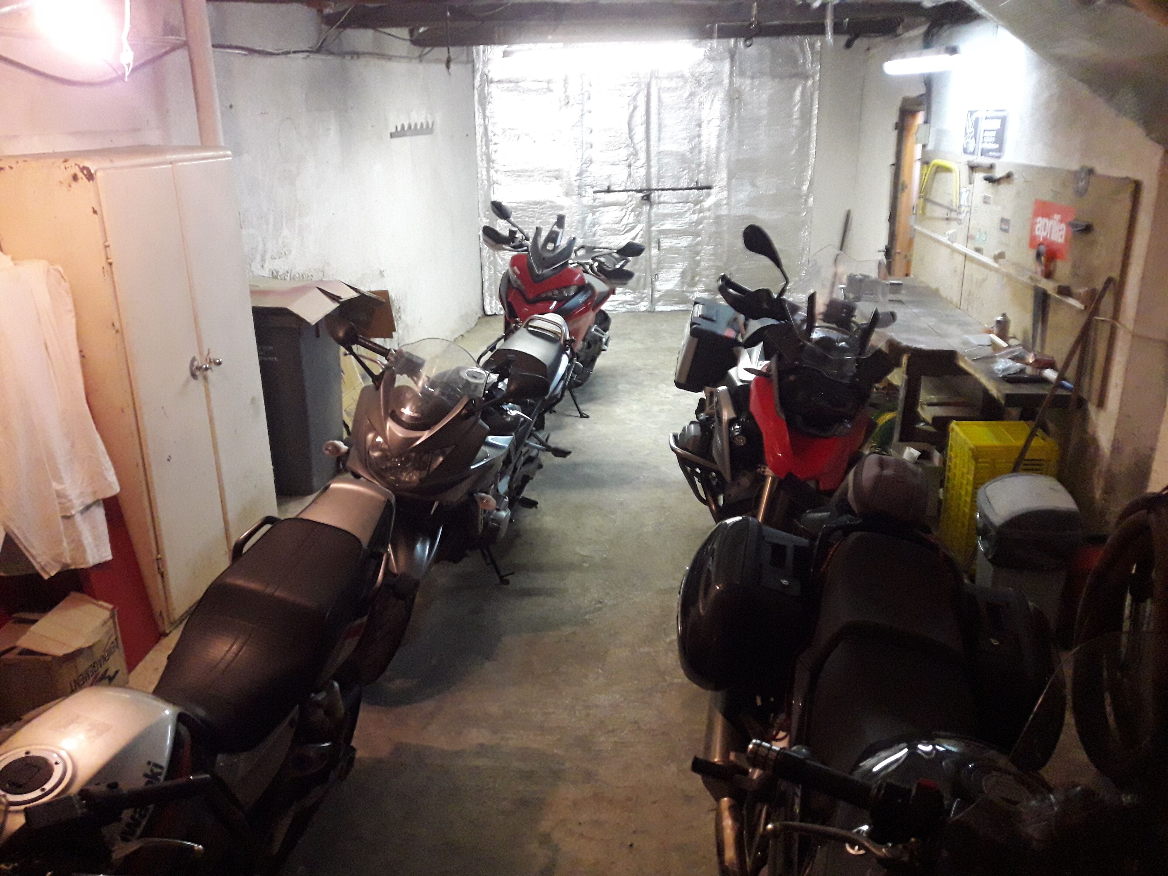 A motorcycle garage with several motorcycles parked in rows.