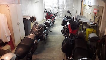 A motorcycle garage with several motorcycles parked in rows.
