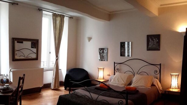 A bedroom with a bed, bedside lamps, a chair, a desk, and a window with curtains. - Belle Occitane (Tarascon-sur-Ariege)