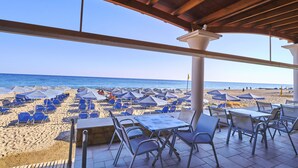 Une terrasse au bord de la plage, avec des sièges extérieurs et une vue sur la plage.