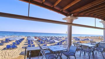 Eine Terrass am Strand mit Sitzgelegenheiten und Blick auf den Strand.