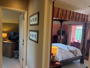 A bedroom with a canopy bed, a television, a lamp, and framed pictures on the wall. - Hunters Rest Inn (Bristol)