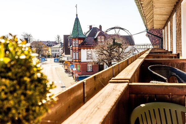 A wooden bridge with a view of traditional buildings and a Ferris wheel in the background. - Der Hirschen (Sankt Maergen)