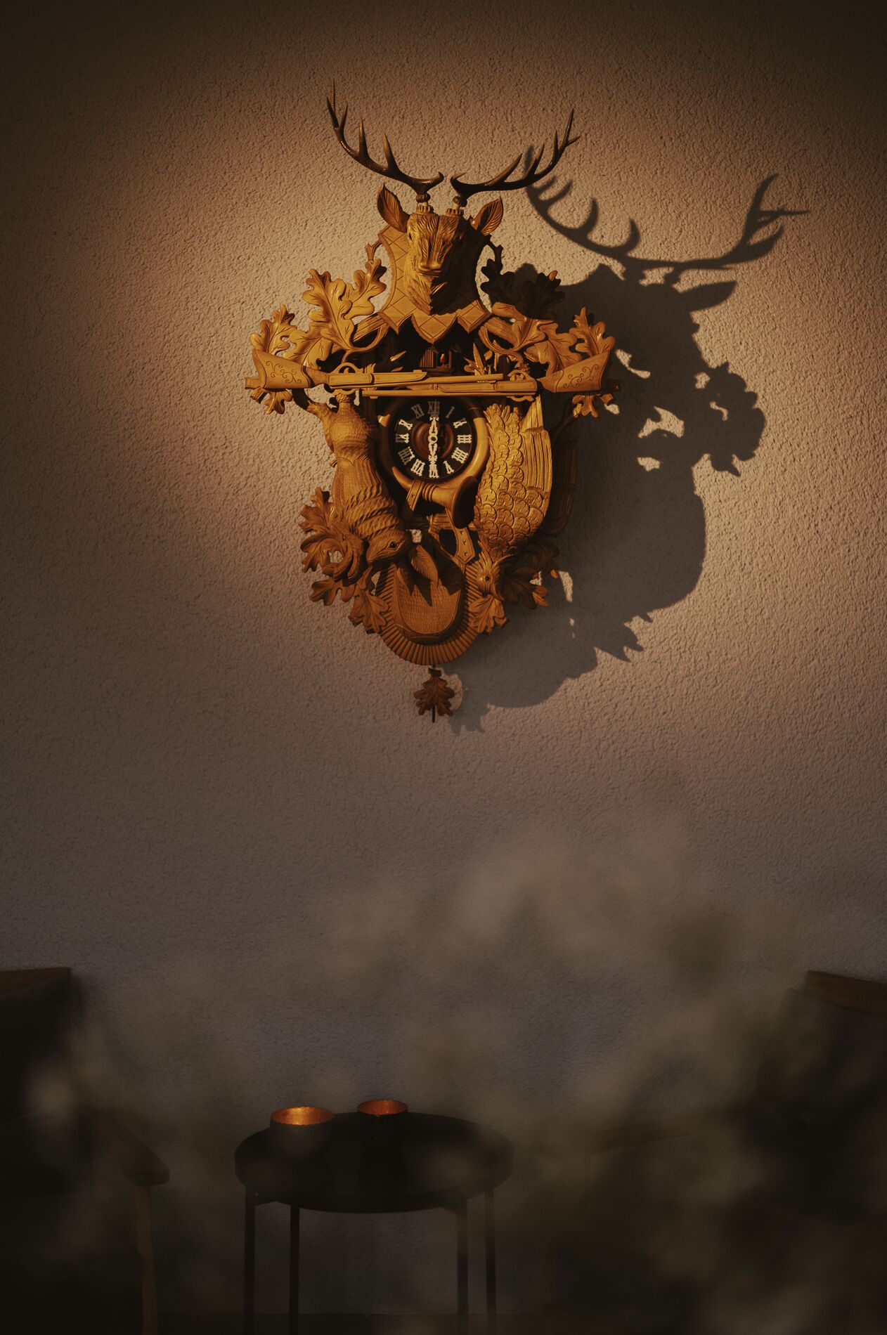 A wall-mounted clock with a deer head and antlers design, featuring Roman numerals.